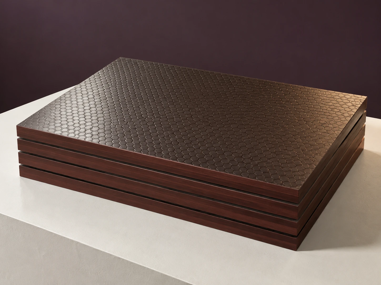 Stack of anti-slip plywood with a dark brown hexagon-embossed film face and sealed edges