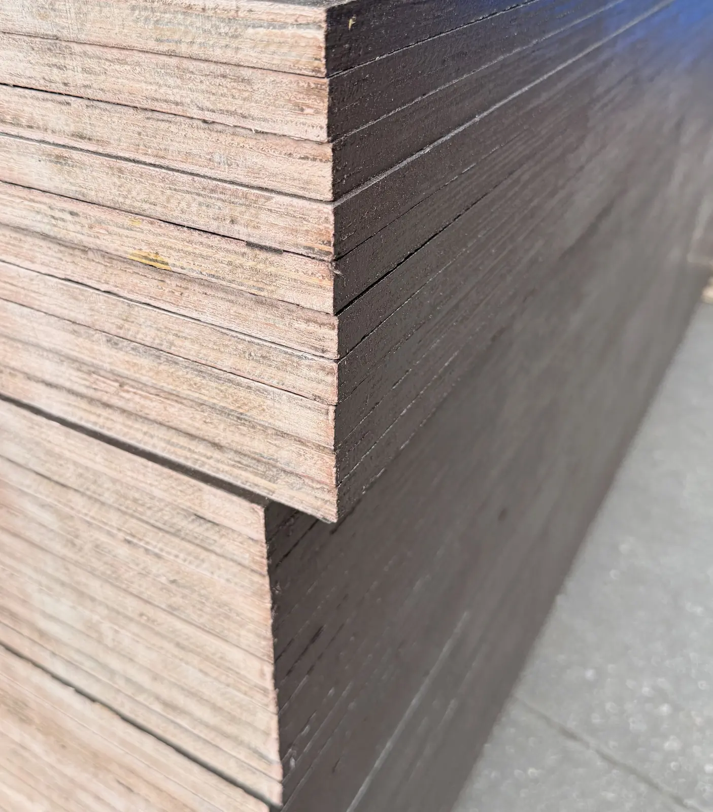 Dark film face and layered edges of film-faced plywood sheets on a pack